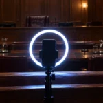Téléphone monté sur un anneau lumineux allumé face à une salle d'audience vide