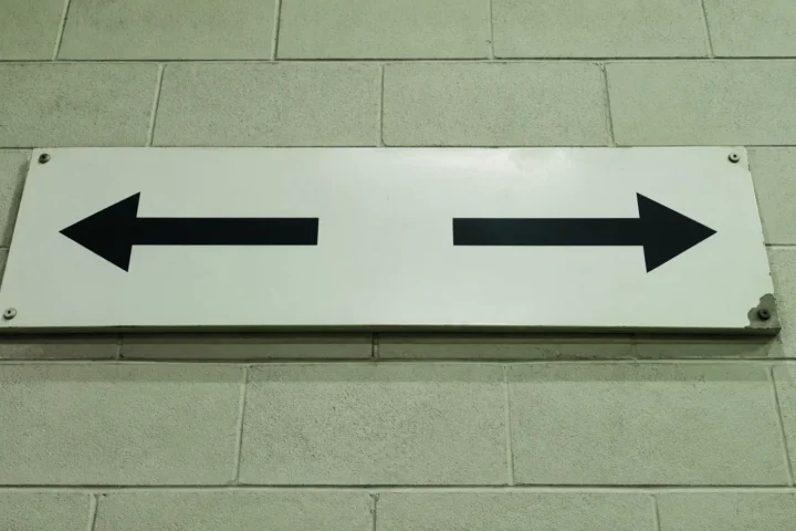 Panneau de signalisation portant deux flèches pointant en sens opposés