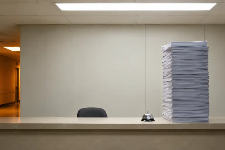 Comptoir de service désert avec sonnette et haute pile de formulaires