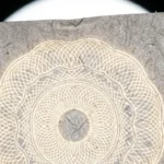 Feuille de papier éclairée à contre-jour révélant un filigrane