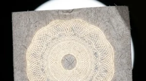 Feuille de papier éclairée à contre-jour révélant un filigrane