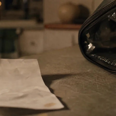 Reçu froissé posé sur un comptoir de cuisine à côté d'un sac de livraison isotherme