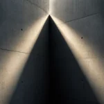Rayon de lumière se divisant en deux faisceaux sur un mur de béton nu