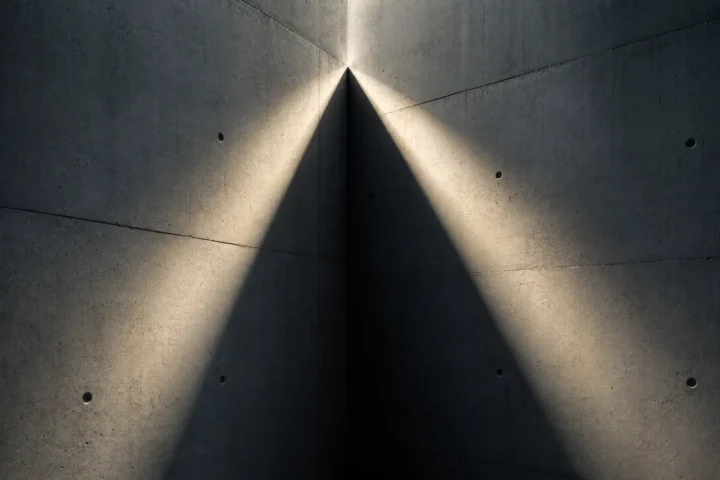 Rayon de lumière se divisant en deux faisceaux sur un mur de béton nu