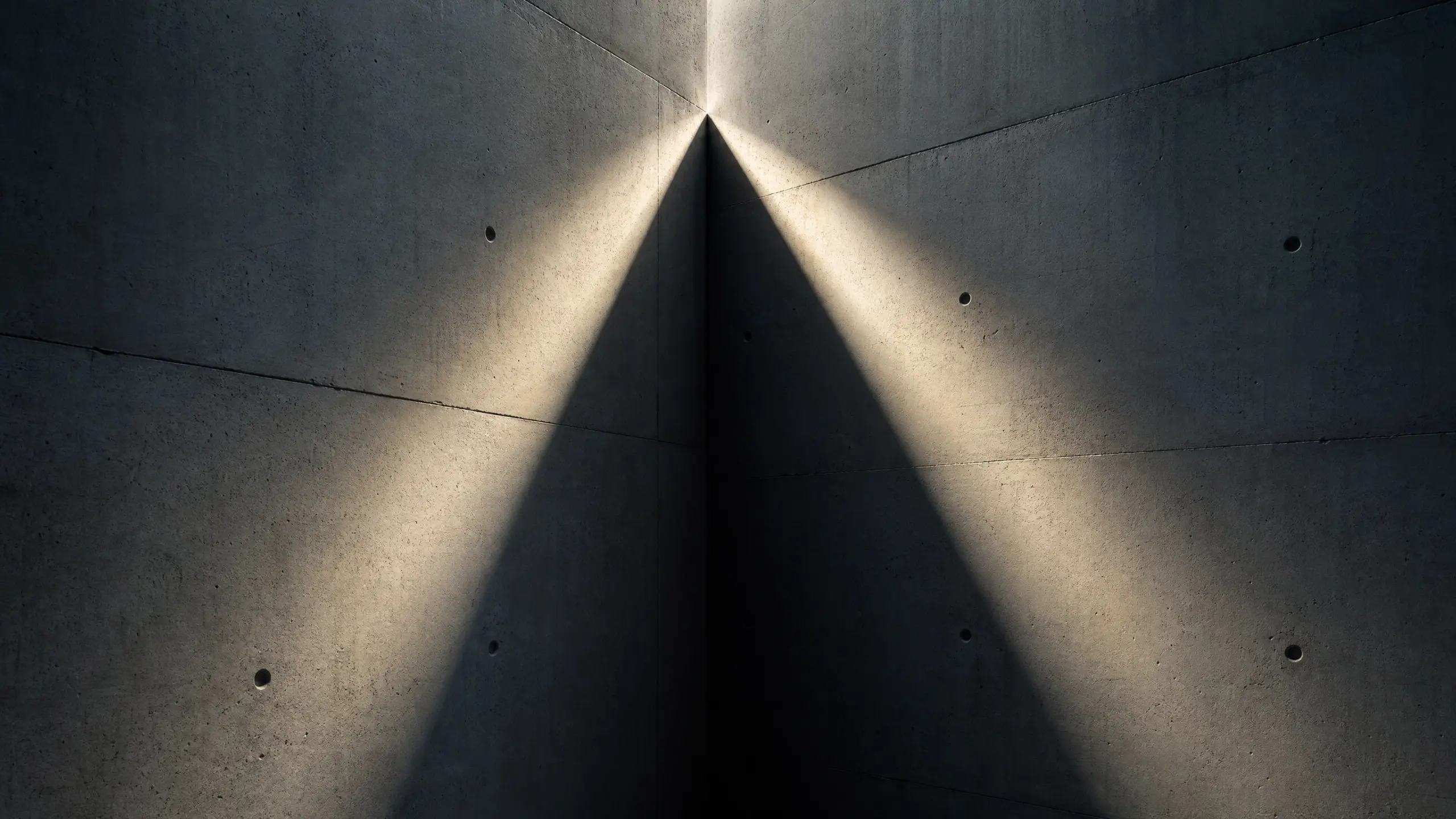 Rayon de lumière se divisant en deux faisceaux sur un mur de béton nu
