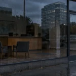 Vitrine d'une agence de voyages fermée, lumières éteintes et comptoir d'accueil vide