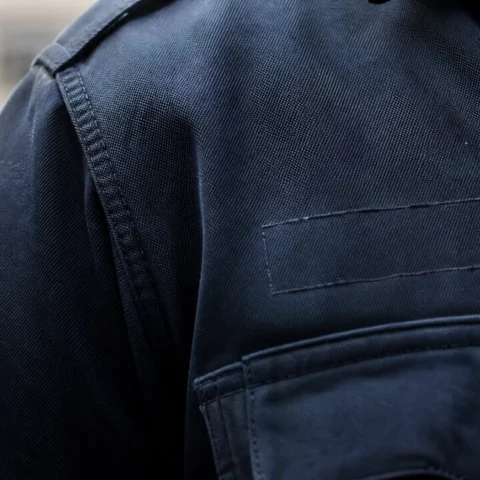 Épaule d'uniforme sombre où l'emplacement de l'identification est vide