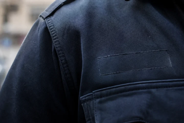 Épaule d'uniforme sombre où l'emplacement de l'identification est vide