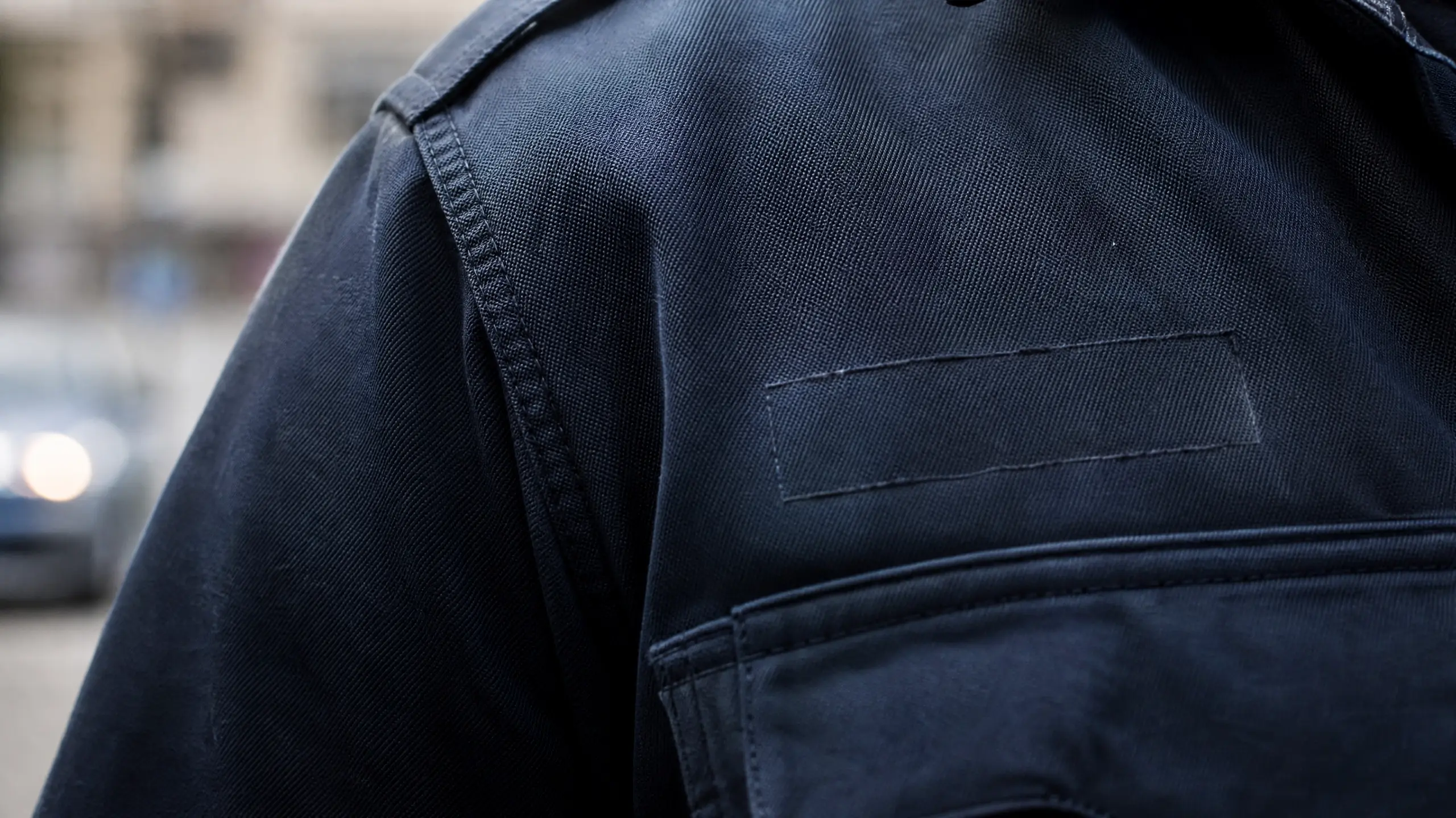 Épaule d'uniforme sombre où l'emplacement de l'identification est vide