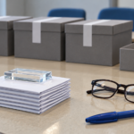 Boîtes de scrutin scellées et bulletins pliés sur une table, une petite pile mise à part