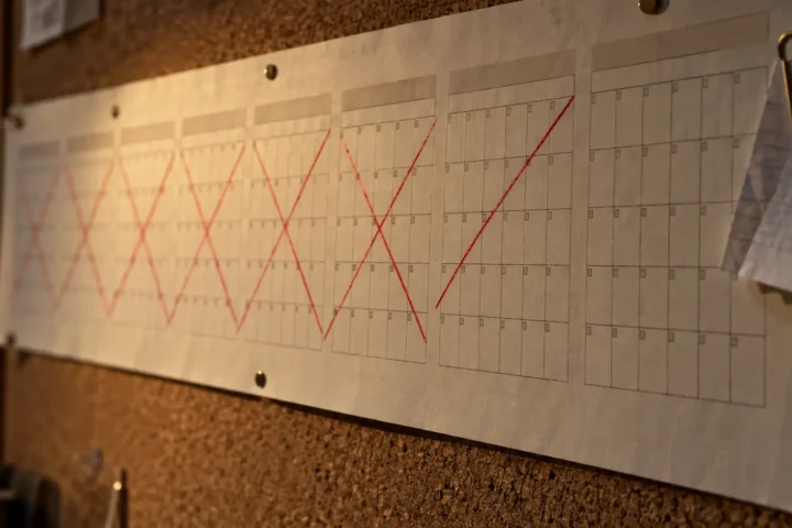 Calendrier mural dont plusieurs mois sont barrés d'une ligne rouge interrompue