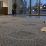 Hall de banque vide après la fermeture, tapis marqué de traces circulaires et pancarte retournée